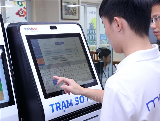 Nhân viên kỹ thuật kiểm tra việc vận hành trạm số hóa tại trụ sở phường Hoàn Kiếm. Ảnh: Văn Điệp – TTXVN