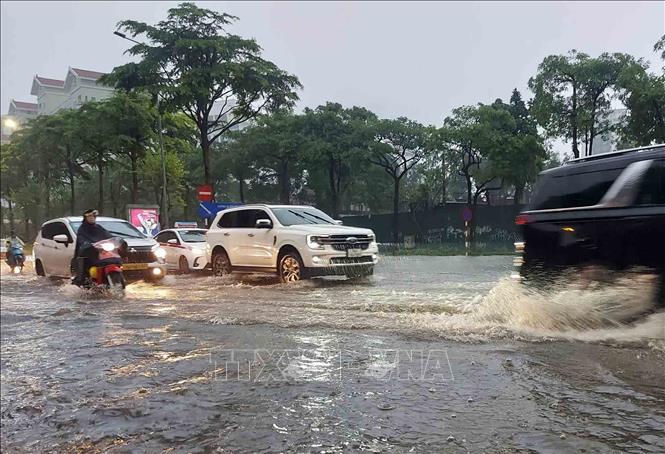Chỉ sau vài phút mưa, tuyến phố Đào Tấn đã ngập úng diện rộng gây ảnh hưởng đến các phương tiện tham gia giao thông. Ảnh: Văn Điệp - TTXVN