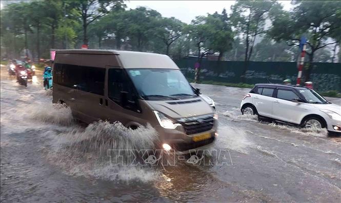 Chỉ sau vài phút mưa, tuyến phố Đào Tấn đã ngập úng diện rộng gây ảnh hưởng đến các phương tiện tham gia giao thông. Ảnh: Văn Điệp - TTXVN