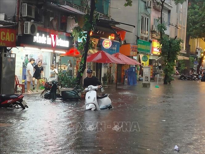 Nước dâng cao ảnh hưởng đến cuộc sống của nhiều hộ dân trên phố Trần Quốc Toản. Ảnh: Hoàng Hiếu - TTXVN 