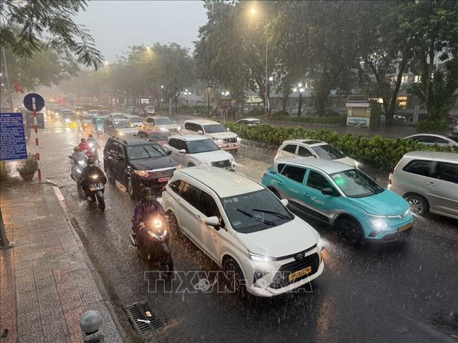 Các phương tiện tham gia giao thông trên tuyến phố Nguyễn Văn Cừ, Long Biên di chuyển khó khăn do mưa lớn gây ngập úng cục bộ. Ảnh: An Đăng - TTXVN