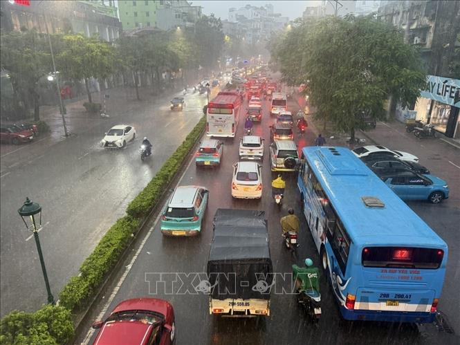 Các phương tiện tham gia giao thông trên tuyến phố Nguyễn Văn Cừ, Long Biên di chuyển khó khăn do mưa lớn gây ngập úng cục bộ. Ảnh: An Đăng - TTXVN