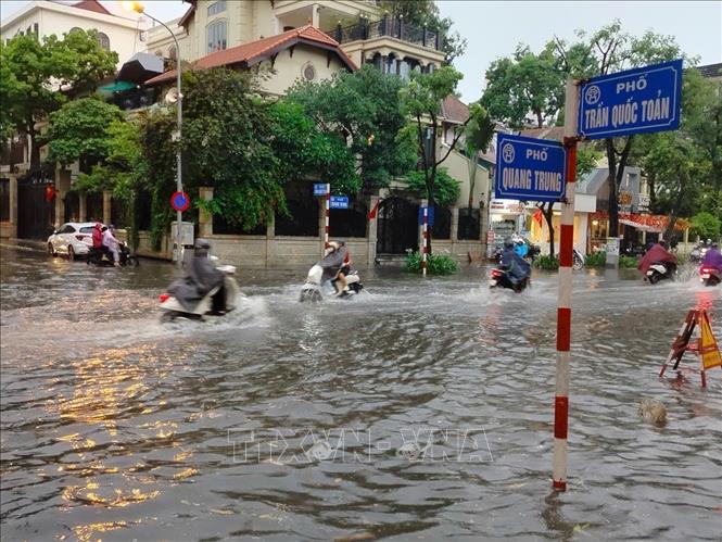 Nước ngập sâu tại ngã tư Trần Quốc Toản - Quang Trung. Ảnh: Hoàng Hiếu - TTXVN 