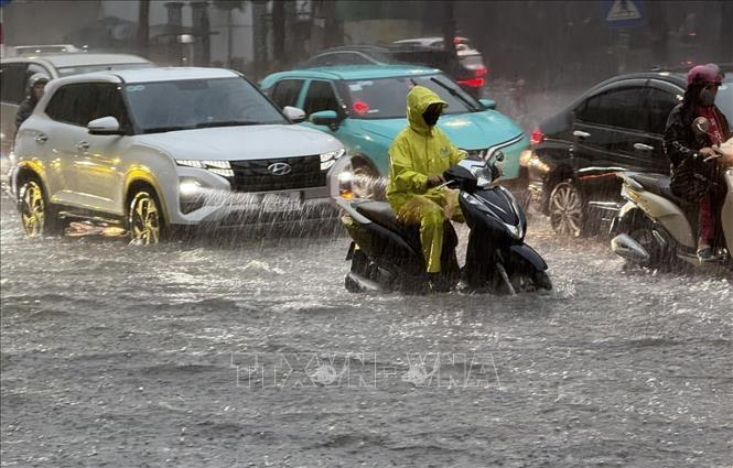 Mưa lớn gây ngập úng cục bộ tuyến phố Nguyễn Văn Cừ, Long Biên khiến các phương tiện tham gia giao thông khó khăn. Ảnh: An Đăng - TTXVN