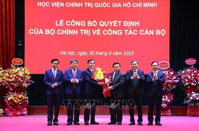 Ban Lãnh đạo Học viện Chính trị quốc gia Hồ Chí Minh chúc mừng ông Đoàn Minh Huấn. Ảnh: Văn Điệp – TTXVN