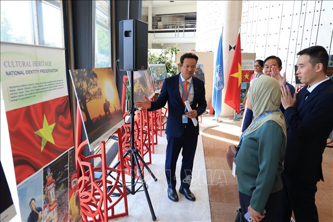 Đại sứ Mai Phan Dũng giới thiệu các tác phẩm cho bạn bè quốc tế. Ảnh: Anh Hiển - PV TTXVN tại Thụy Sĩ 