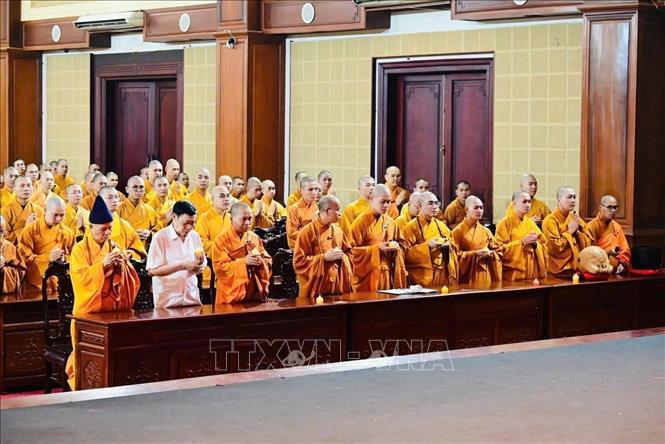 Các chư tăng, cư sỹ thắp nến cầu nguyện quốc thái dân an. Ảnh: TTXVN phát