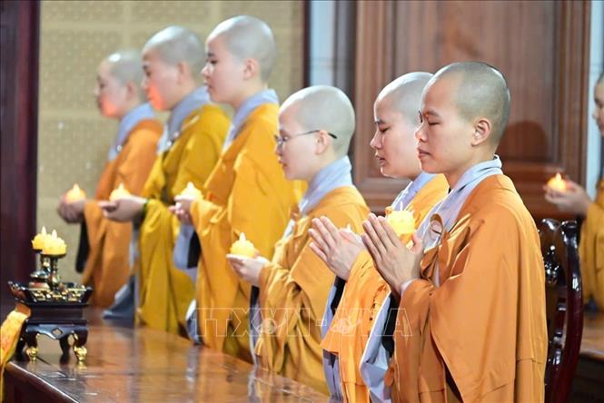 Các chư ni thắp nến cầu nguyện quốc thái dân an. Ảnh: TTXVN phát