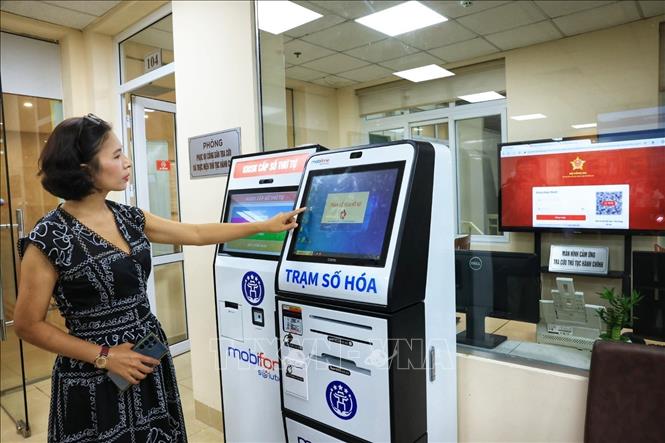 Người dân lấy số thứ tự xếp hàng làm thủ tục hành chính tại Trung tâm phục vụ hành chính công phường Hoàn Kiếm, số 126 phố Hàng Trống. Ảnh: Tuấn Anh - TTXVN 