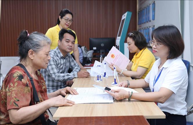 Cán bộ hỗ trợ người dân giải quyết thủ tục tại trụ sở UBND phường Việt Hưng, số 1 Vạn Hạnh. Ảnh: Thành Phương – TTXVN