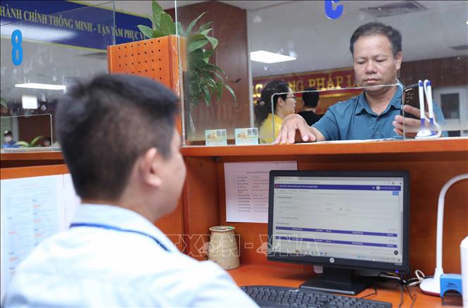 Người dân làm thủ tục tại trụ sở UBND phường Việt Hưng, số 1 Vạn Hạnh. Ảnh: Thành Phương – TTXVN