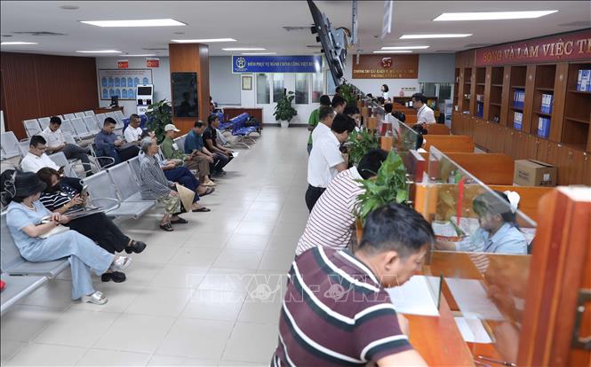 Người dân đến làm thủ tục tại Trụ sở UBND phường Việt Hưng. Ảnh: Thành Phuơng – TTXVN