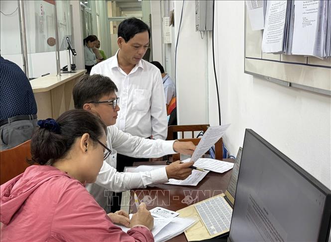 Không khí làm việc tại Trung tâm hành chính công phường Gia Định trong ngày đầu tiên chính thức vận hành bộ máy chính quyền mới. Ảnh: Hữu Duyên-TTXVN 