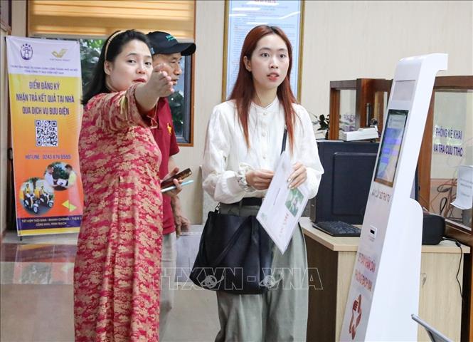 Hướng dẫn người dân đến làm thủ tục hành chính tại phường Bạch Mai, số 33 phố Đại Cồ Việt. Ảnh: Khánh Hoà - TTXVN