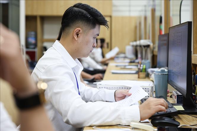Cán bộ UBND phường Ngọc Hà hỗ trợ người dân giải quyết thủ tục hành chính. Ảnh: Lê Đông - TTXVN