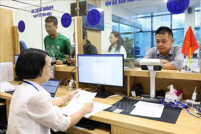 Cán bộ UBND phường Ngọc Hà hỗ trợ người dân giải quyết thủ tục hành chính. Ảnh: Lê Đông - TTXVN
