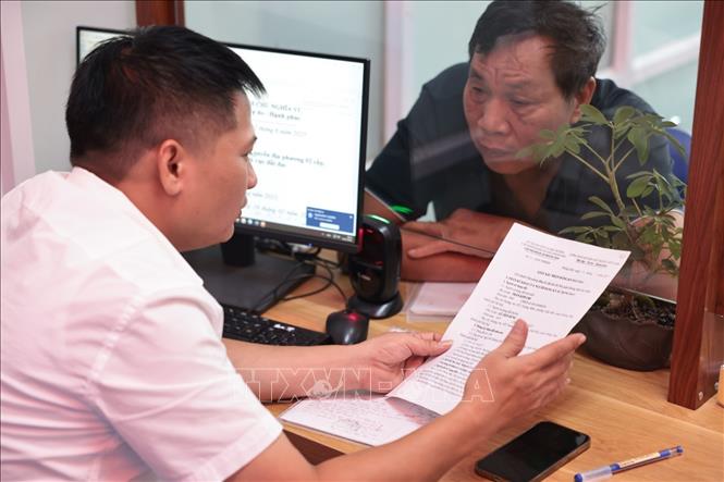 Người dân phường Hoàng Mai đến làm thủ tục hành chính tại trụ sở UBND phường, số 6, Bùi Huy Bích. Ảnh: Trần Việt - TTXVN