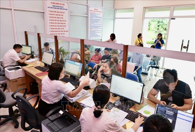 Bộ phận hành chính công của UBND phường Hoàng Mai (số 6, Bùi Huy Bích) giải quyết thủ tục hành chính cho người dân. Ảnh: Trần Việt - TTXVN 
