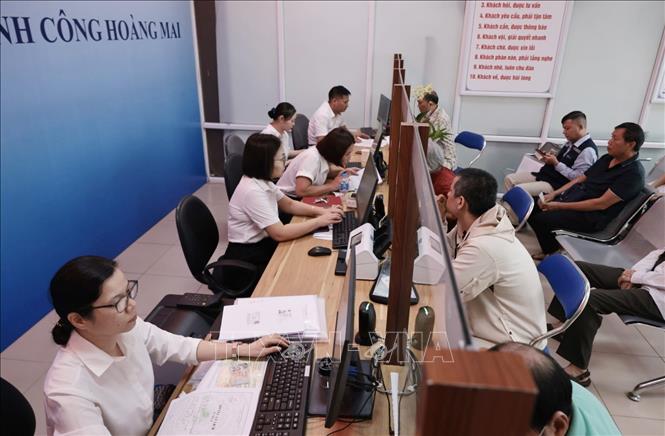 Người dân phường Hoàng Mai đến làm thủ tục hành chính tại bộ phận hành chính công của UBND phường, số 6 Bùi Huy Bích. Ảnh: Trần Việt - TTXVN
