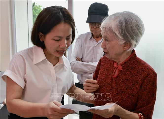 Cán bộ bộ phận hành chính công phường Hoàng Mai hướng dẫn người dân đến làm thủ tục hành chính. Ảnh: Trần Việt - TTXVN 