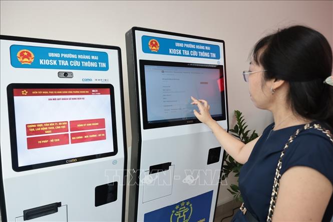 Người dân lấy số làm thủ tục hành chính tại bộ phận phục vụ hành chính công của UBND phường Hoàng Mai, số 6 phố Bùi Huy Bích. Ảnh: Trần Việt - TTXVN 