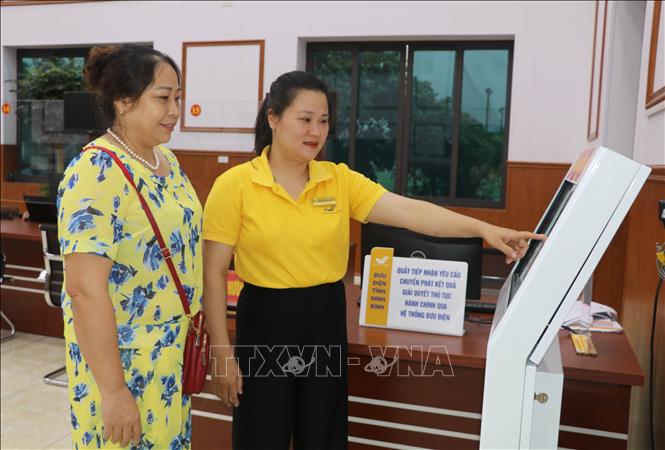 Cán bộ Trung tâm phục vụ hành chính công phường Hoa Lư, tỉnh Ninh Bình hướng dẫn người dân đến làm thủ tục hành chính. Ảnh: Thùy Dung - TTXVN