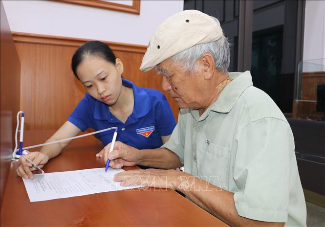 Đoàn viên, thanh niên phường Hoa Lư, tỉnh Ninh Bình được huy động hỗ trợ, hướng dẫn người dân thực hiện các thủ tục hành chính. Ảnh: Thùy Dung - TTXVN