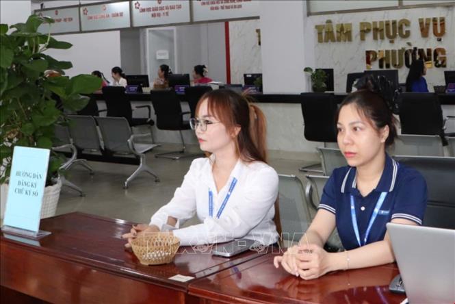 Cán bộ Trung tâm hành chính công phường Dĩ An sẵn sàng phục vụ người dân từ sáng ngày 1/7. Ảnh: Huyền Trang - TTXVN 