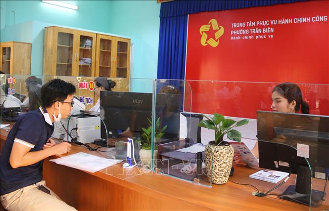 Người dân làm thủ tục hành chính tại Trung tâm phục vụ hành chính công phường Trấn Biên. Ảnh: Công Phong - TTXVN
