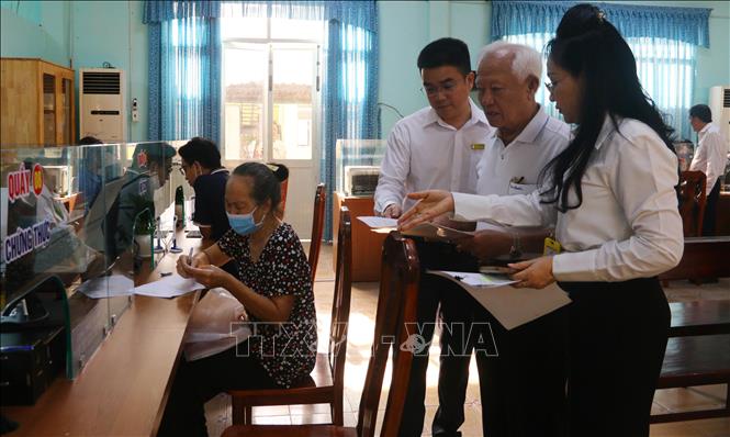 Cán bộ phường Trấn Biên hướng dẫn người dân làm thủ tục hành chính. Ảnh: Công Phong - TTXVN