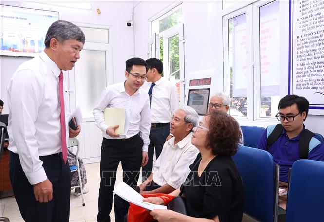 Lãnh đạo phường Hồng Hà hỏi thăm người dân đến làm thủ tục hành chính. Ảnh: Văn Điệp - TTXVN