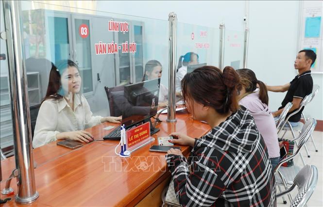 Cán bộ Trung tâm phục vụ hành chính công hướng dẫn người dân đến làm các thủ tục hành chính. Ảnh: Quý Trung – TTXVN