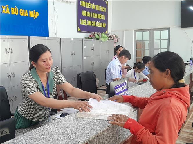 Người dân thực hiện các thủ tục hành chính tại Trung tâm phục vụ hành chính công xã Bù Gia Mập. Ảnh: K GỬIH-TTXVN 
