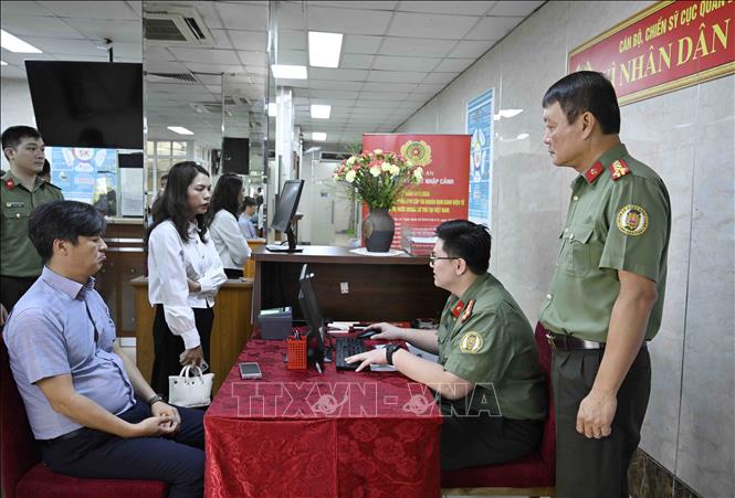 Cán bộ, chiến sĩ Cục quản lý xuất nhập cảnh, Bộ Công an tiếp nhận nhập thông tin người nước ngoài cung cấp vào hệ thống định danh và xác thực điện tử. Ảnh: Phạm Kiên - TTXVN