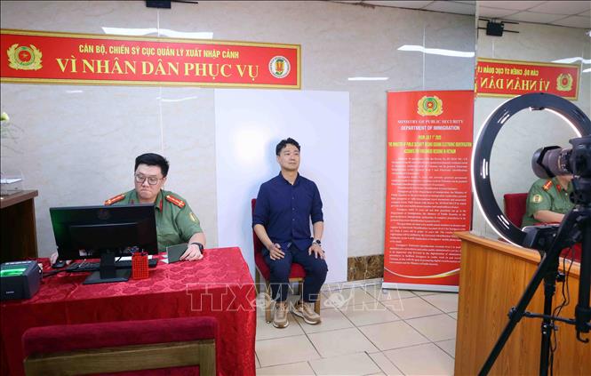 Thu nhận ảnh khuôn mặt của người nước ngoài cư trú tại Việt Nam đến làm thủ tục cấp tài khoản định danh điện tử. Ảnh: Phạm Kiên - TTXVN