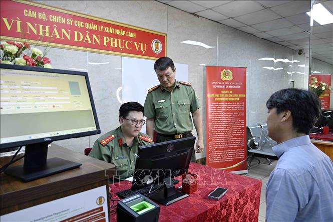 Cán bộ, chiến sĩ Cục quản lý xuất nhập cảnh, Bộ Công an tiếp nhận nhập thông tin người nước ngoài cung cấp vào hệ thống định danh và xác thực điện tử. Ảnh: Phạm Kiên - TTXVN