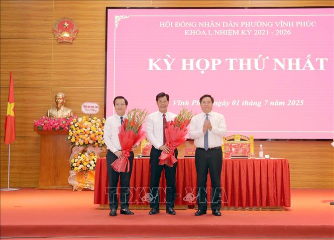 Chủ tịch UBND tỉnh Phú Thọ Trần Duy Đông (phải) tặng hoa chúc mừng lãnh đạo UBND phường Vĩnh Phúc tại kỳ họp. Ảnh: Hoàng Hùng-TTXVN