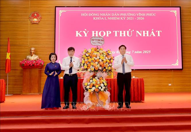 Chủ tịch UBND tỉnh, Phó Bí thư Tỉnh ủy Phú Thọ Trần Duy Đông (phải) tặng hoa chúc mừng lãnh đạo phường Vĩnh Phúc tại kỳ họp. Ảnh: Hoàng Hùng-TTXVN