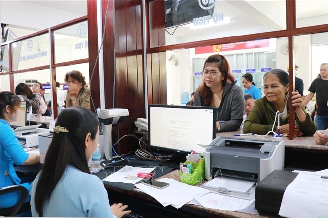 Người dân liên hệ bộ phận một cửa giải quyết các vấn đề liên quan hộ tịch ở phường Nha Trang, tỉnh Khánh Hòa trong ngày làm việc đầu tiên của chính quyền 2 cấp. Ảnh: Phan Sáu - TTXVN