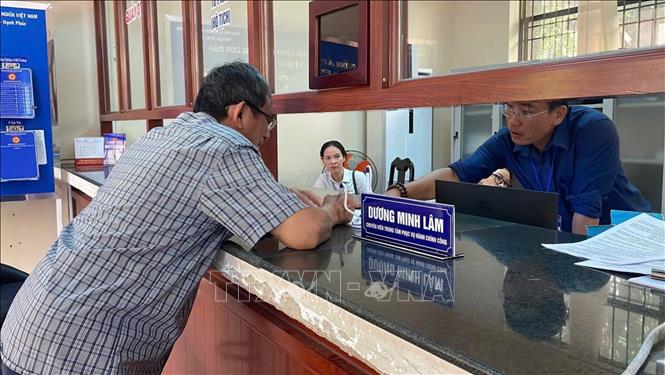 Cán bộ hướng dẫn tận tình cho người dân thực hiện thủ tục hành chính công trong ngày đầu tiên vận hành chính quyền 2 cấp mới. Ảnh: Hoàng Nhị - TTXVN