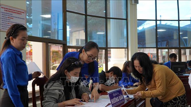 Đoàn viên thanh niên phường Rạch Giá hỗ trợ người dân thực hiện các thủ tục. Ảnh: Văn Sĩ - TTXVN                                 