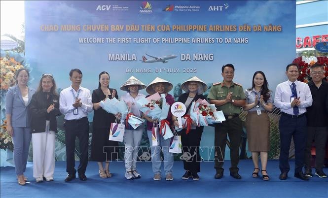 Tặng hoa, quà cho các hành khách đầu tiên đến thành phố bằng đường bay thẳng Manila – Đà Nẵng. Ảnh: Trần Lê Lâm - TTXVN 