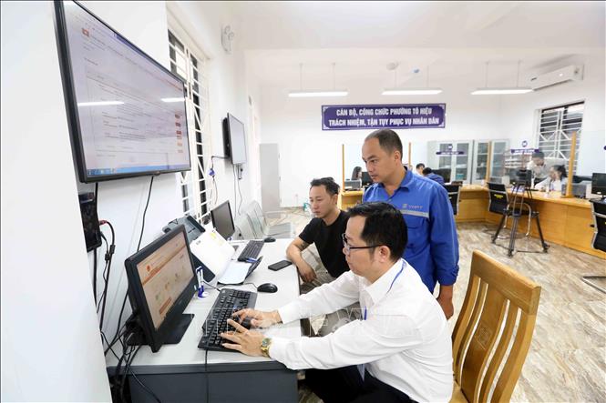 Cán bộ, nhân viên Trung tâm Phục vụ Hành chính công phường Tô Hiệu làm thủ tục hành chính cho người dân. Ảnh: Quang Quyết - TTXVN