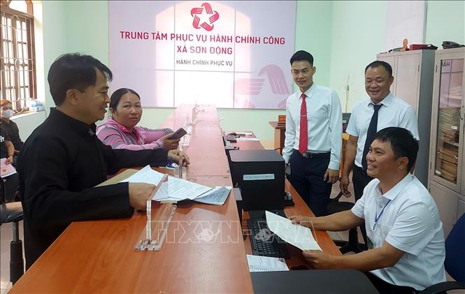 Cán bộ hướng dẫn người dân thực hiện các thủ tục hành chính tại Trung tâm hành chính công xã Sơn Động. Ảnh: Đồng Thúy - TTXVN