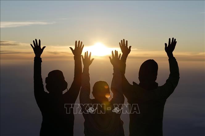 Những người leo núi đón bình minh trên đỉnh núi Phú Sĩ, Nhật Bản ngày 1/7/2025. Ảnh: Kyodo/TTXVN