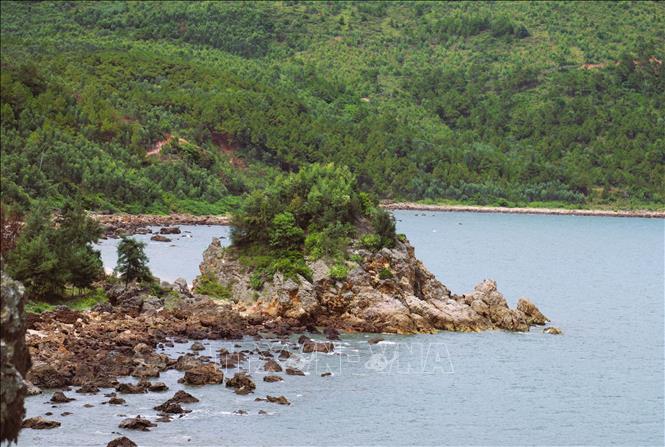 Một hòn núi nhỏ nằm tách biệt ra bờ biển dưới chân dãy núi đá vôi Mành Sơn, cách cửa biển Lạch Quèn chỉ hơn 100m. Ảnh: Xuân Tiến-TTXVN  