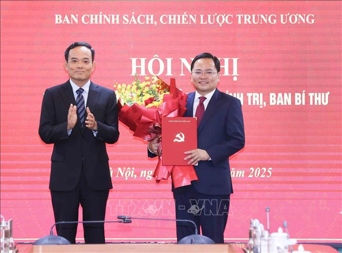 Đồng chí Trần Lưu Quang, Bí thư Trung ương Đảng, Trưởng Ban Chính sách, chiến lược Trung ương trao Quyết định của Bộ Chính trị, Ban Bí thư cho đồng chí Nguyễn Anh Tuấn. Ảnh: Phương Hoa - TTXVN