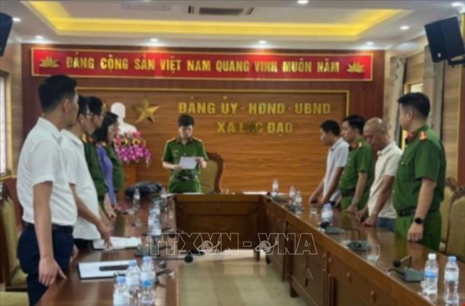 Cơ quan cảnh sát điều tra Công an tỉnh Hưng Yên đọc quyết định khởi tố bị can và lệnh bắt bị can để tạm giam đối với 2 đối tượng. Ảnh: TTXVN phát