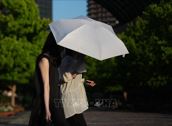 Người dân di chuyển trên đường phố dưới trời nắng nóng tại Tokyo, Nhật Bản. Ảnh: THX/TTXVN