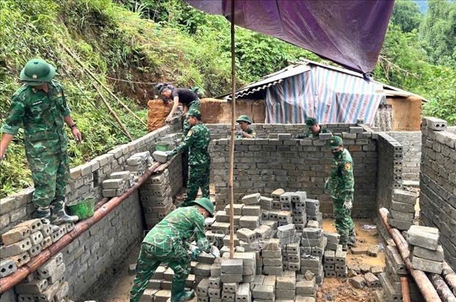 The border guards in the northern province of Lai Chau assist locals in building new houses. VNA/Photo by courtesy